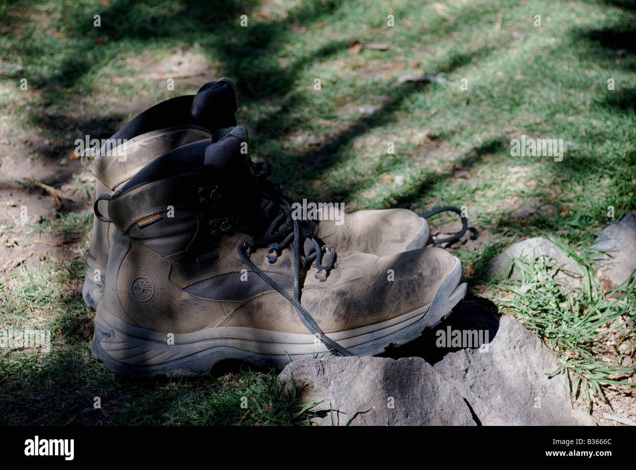 Indossare scarpe fuori seduta nella luce solare dopo trek Foto Stock
