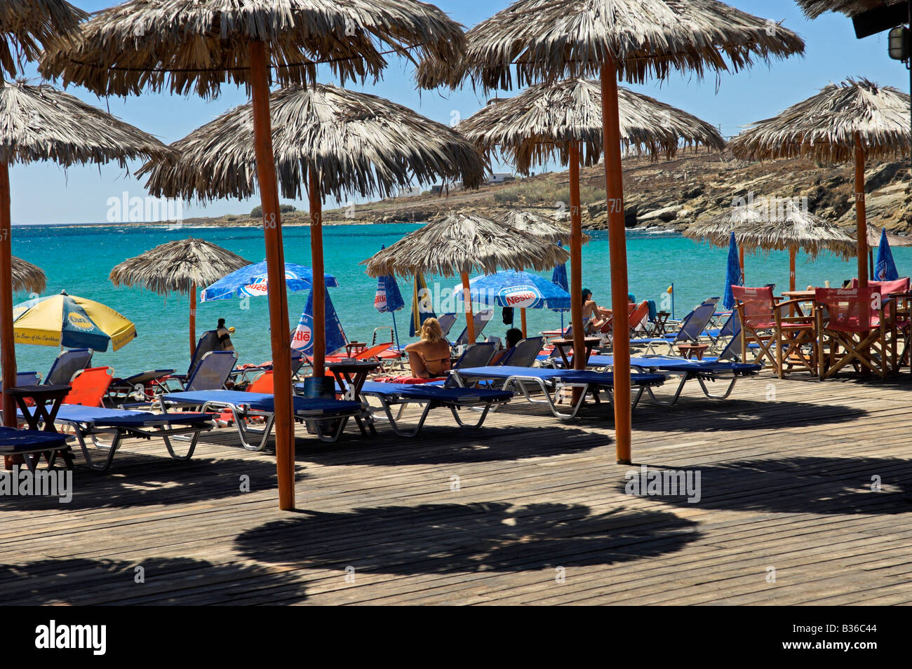 Ombrelloni e sedie a sdraio sul Boardwalk deck all 'Grecia POUNTA beach " isola di Paros Grecia Foto Stock