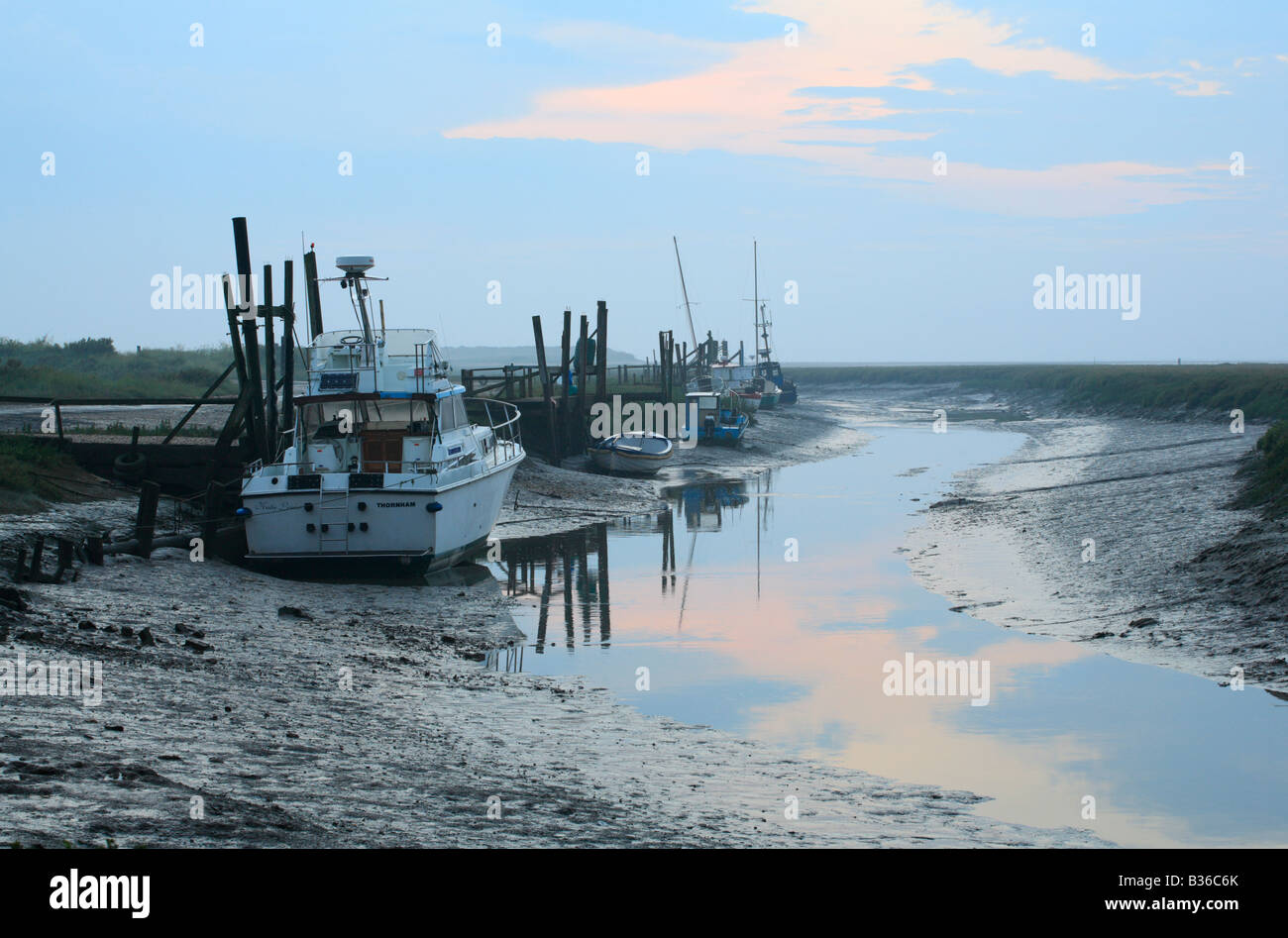 Barche a bassa marea a Thornham porto sulla costa di Norfolk. Foto Stock