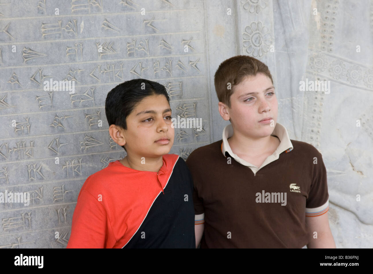 La diversità in Iran due ragazzi posano per una foto con le rovine di Persepoli in Iran Foto Stock