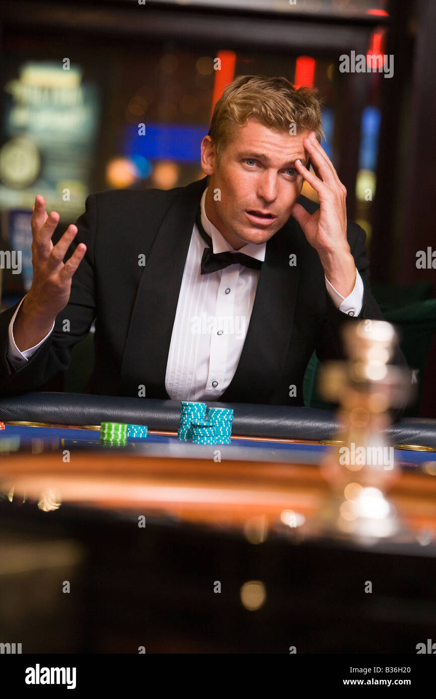 Uomo in casinò giocare alla roulette e perdere (messa a fuoco selettiva) Foto Stock