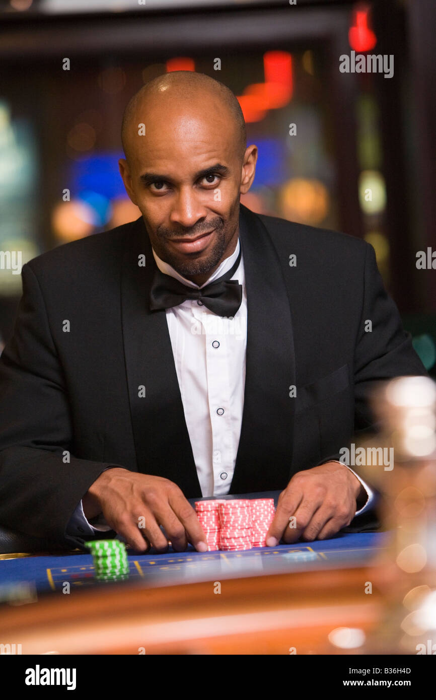 Uomo in casinò giocare alla roulette sorridente (messa a fuoco selettiva) Foto Stock Uomo in casinò giocare alla roulette sorridente (messa a fuoco selettiva) Foto Stock