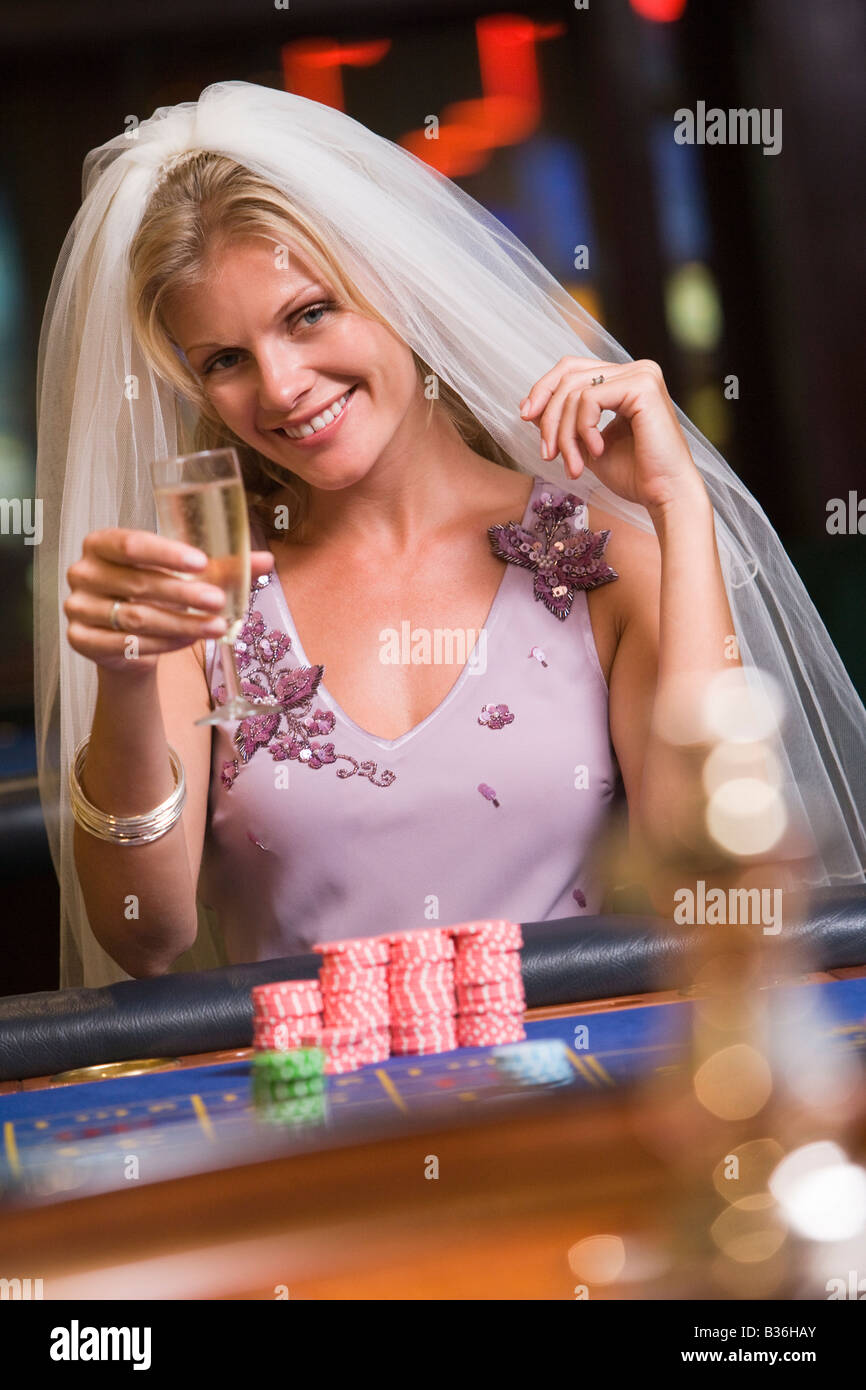 Donna in velo nuziale nel casinò giocare alla roulette e sorridente (messa a fuoco selettiva) Foto Stock