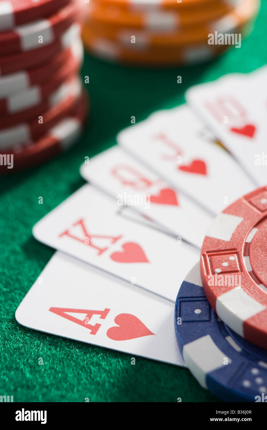 Carte da gioco rendendo royal flush in cuori da poker chips (close up/messa a fuoco selettiva) Foto Stock