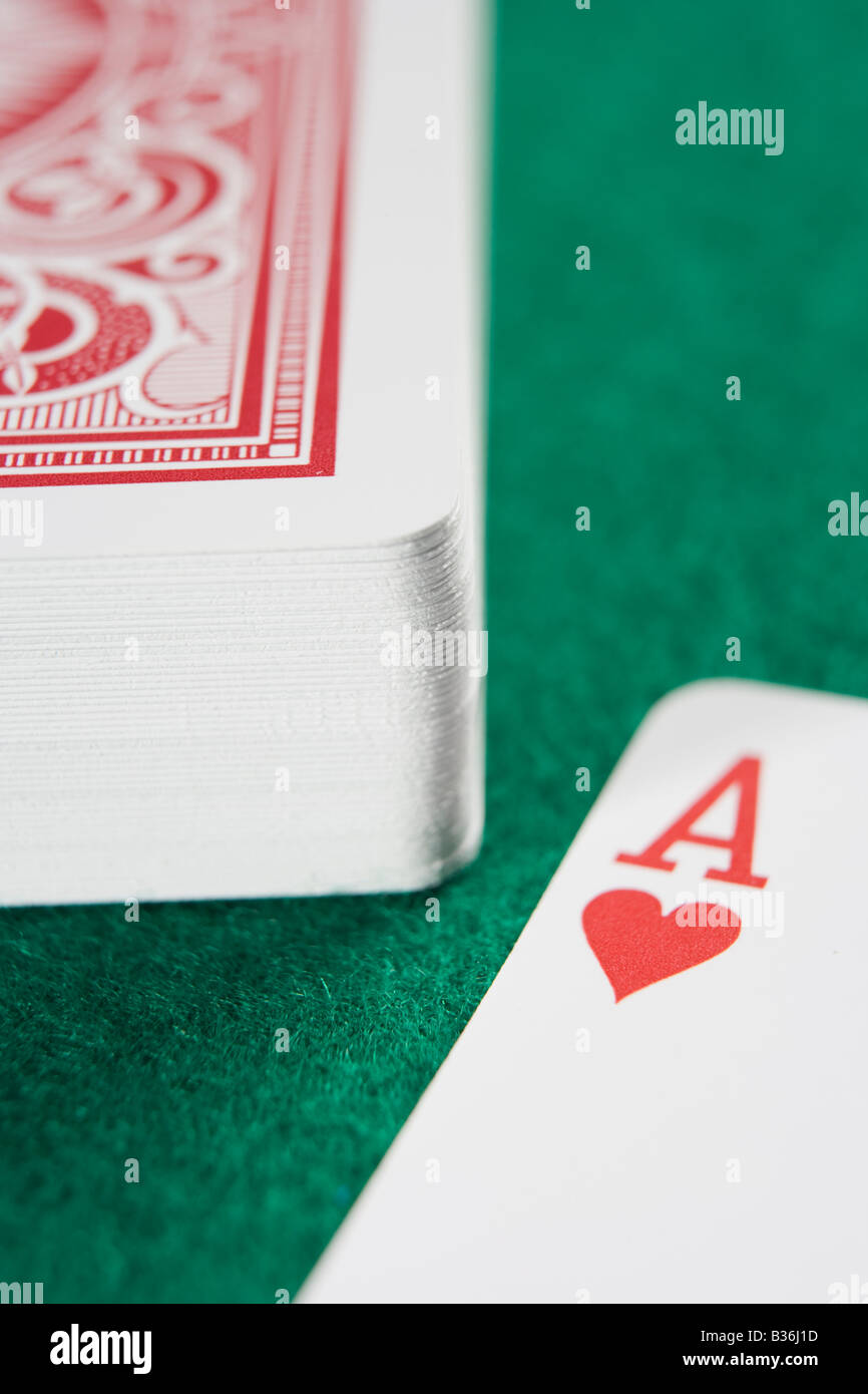 Mazzo di carte sul tavolo del poker con asso di cuori che mostra (close up/messa a fuoco selettiva) Foto Stock