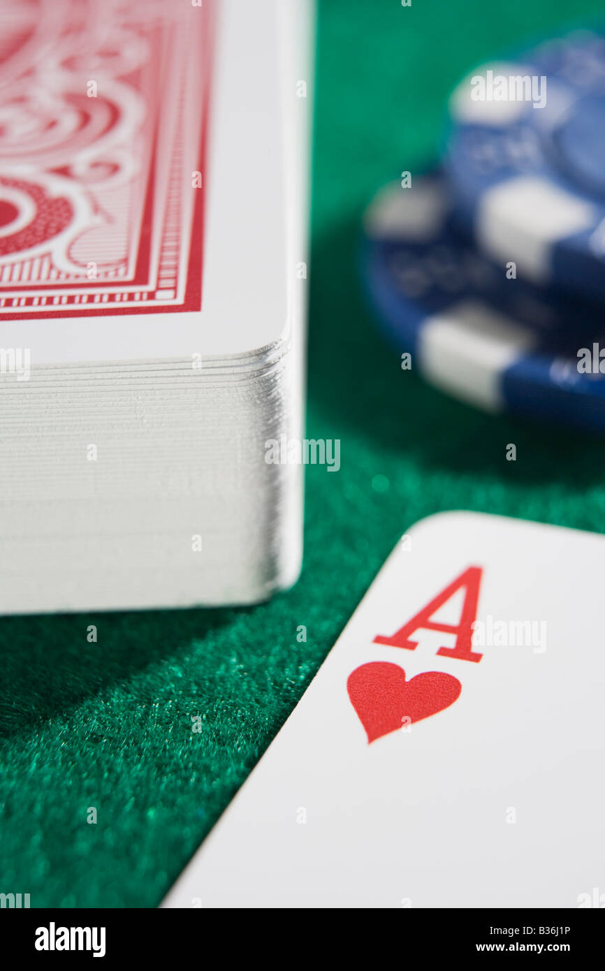 Mazzo di carte e poker chips su un tavolo del poker con asso di cuori che mostra (close up/messa a fuoco selettiva) Foto Stock