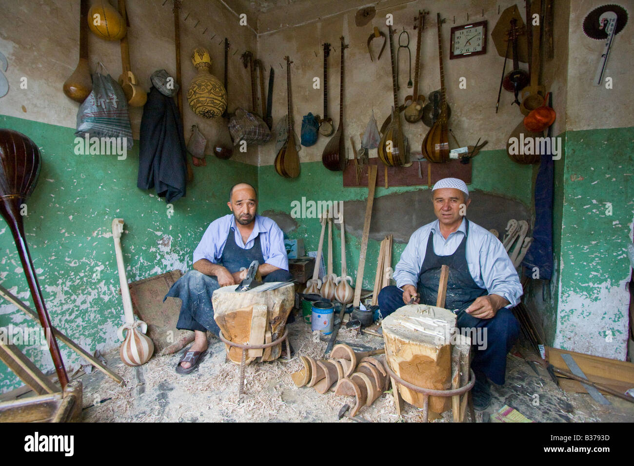 Uyghur gli artigiani produrre legno tradizionali strumenti musicali a Kashgar nella provincia dello Xinjiang Cina Foto Stock