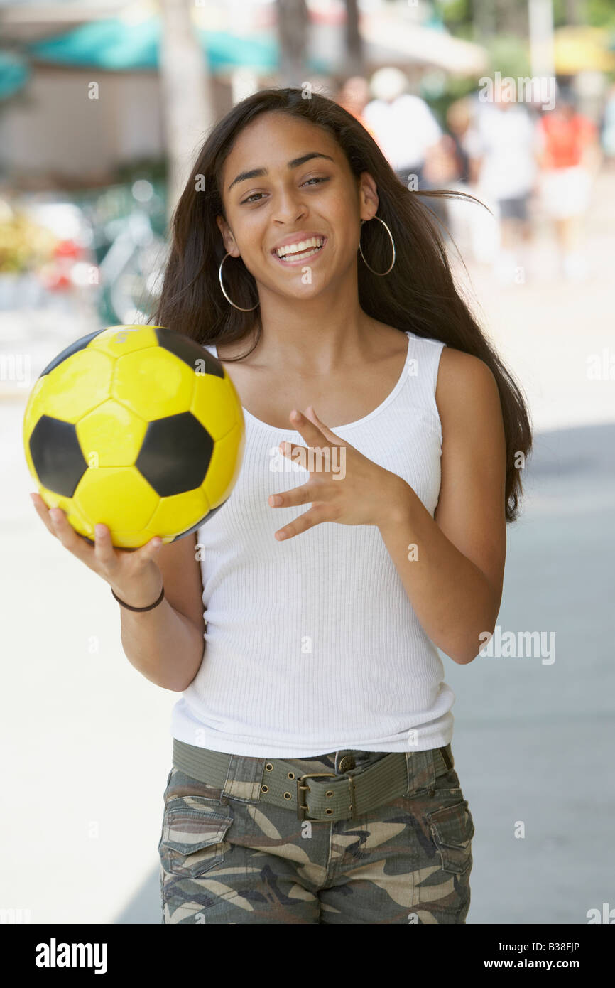 Gara di misto ragazza adolescente tenendo palla calcio Foto Stock