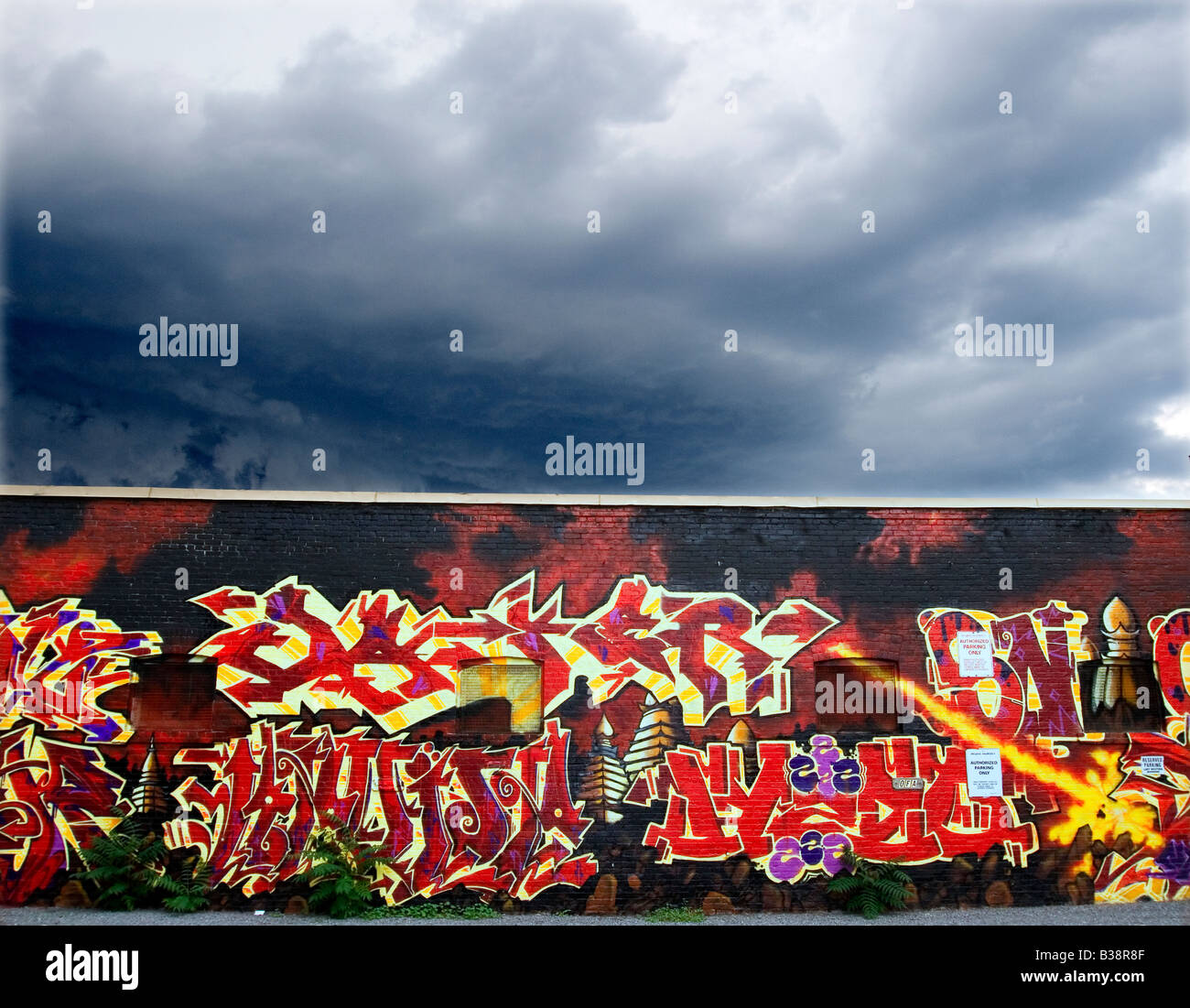 Graffiti su un muro di strada contro una nube di tuono Foto Stock