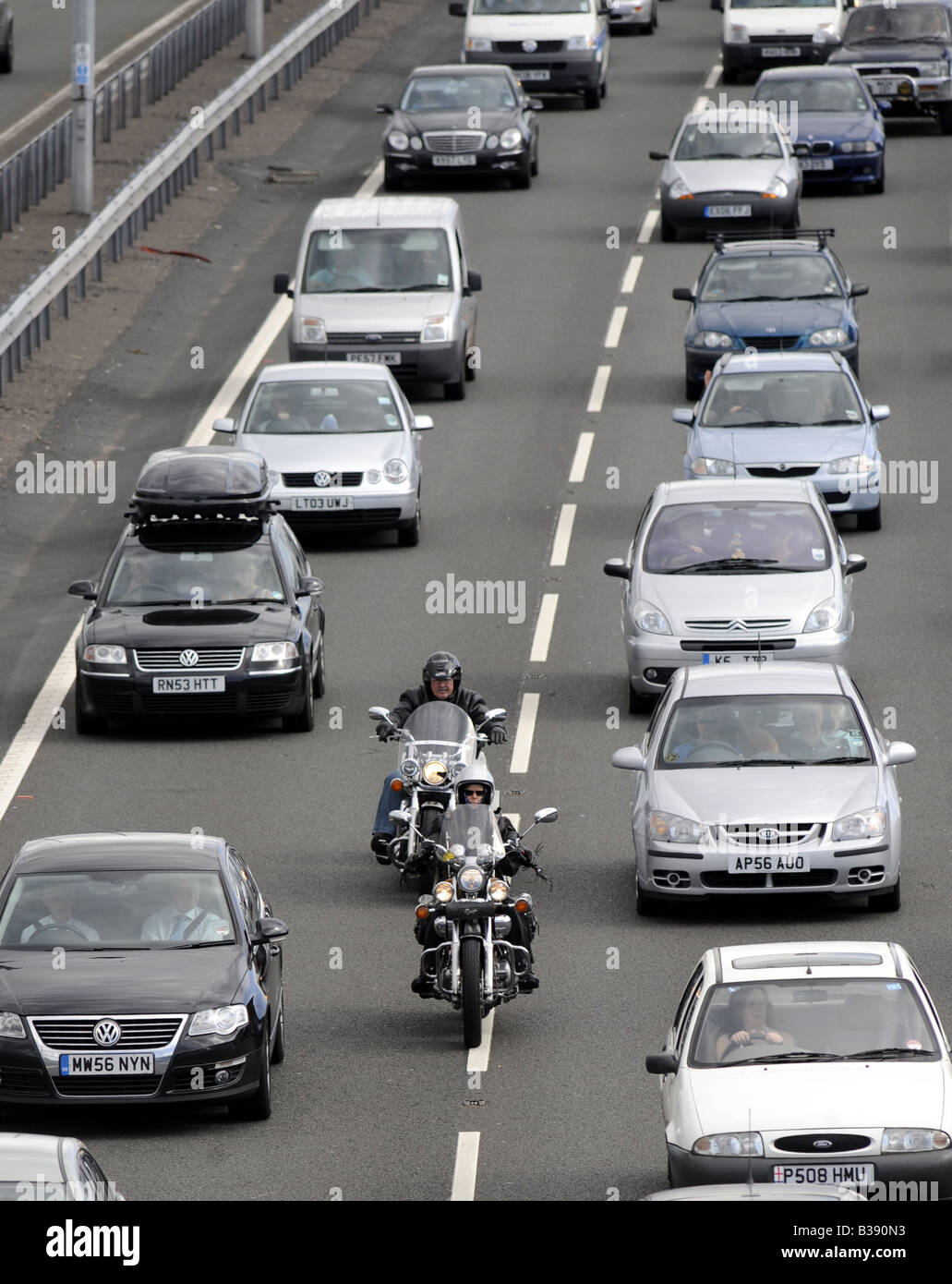 Motociclisti filtrando attraverso il traffico pesante sulla autostrada M6,vicino allo svincolo 11,CANNOCK, STAFFORDSHIRE, Regno Unito. Foto Stock