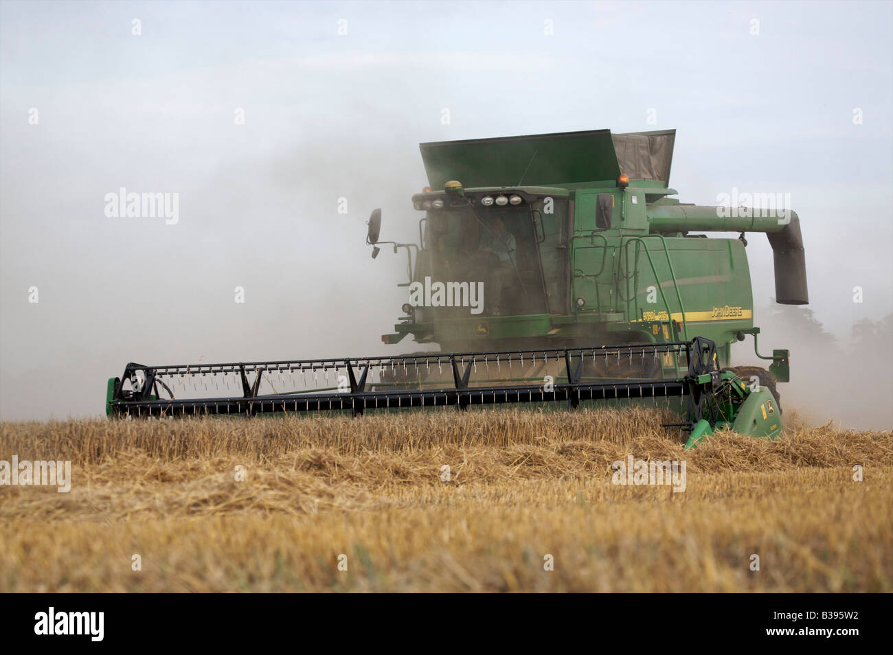 Mietitrebbia John Deere la raccolta di frumento invernale in condizioni polverose Foto Stock