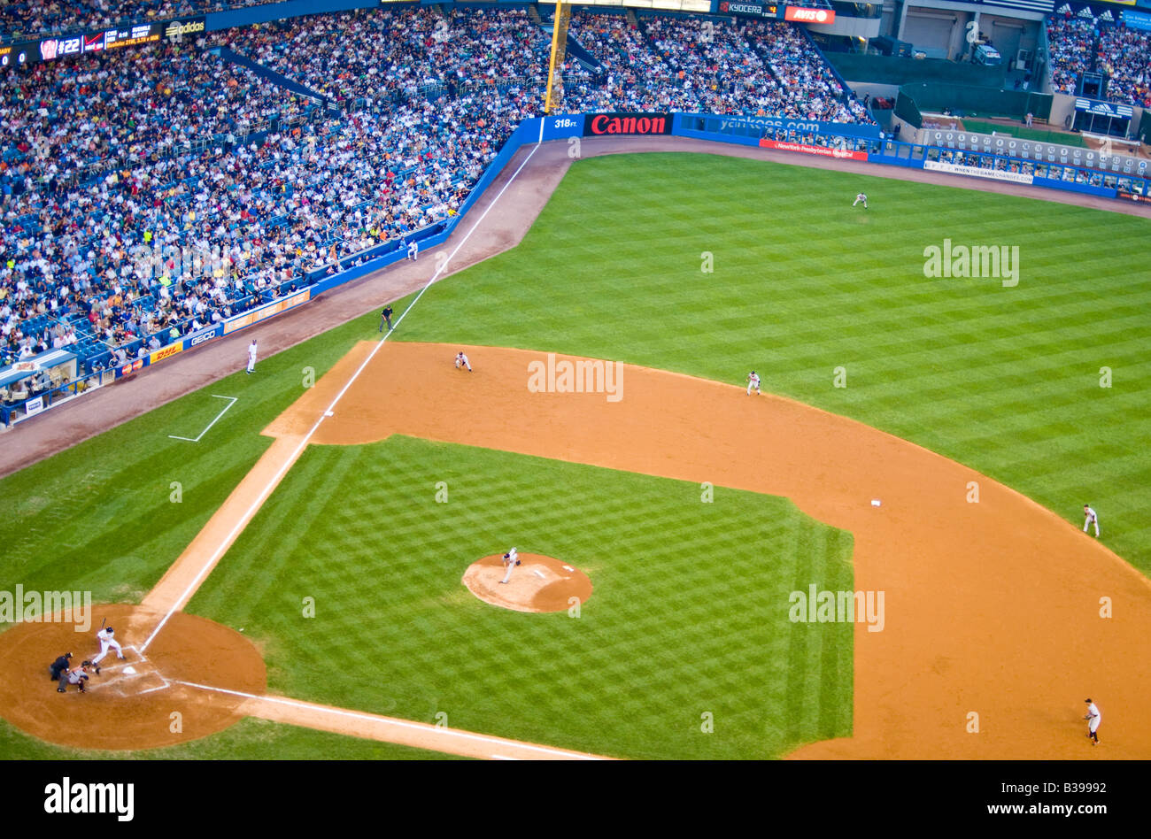 Yankee Stadium Baseball Game New York City // THE BRONX, New York City, Stati Uniti — Una partita di baseball è in corso presso il vecchio Yankee Stadium, con i New York Yankees che affrontano i Baltimore Orioles. Il luogo iconico, noto come "la casa che Ruth ha costruito", ospita una folla di appassionati appassionati che guardano il passatempo americano. Lo storico stadio, con la sua caratteristica facciata e il Monument Park, fa da sfondo alle tradizioni del baseball, mentre due rivali dell'American League East competono sul diamante. Foto Stock