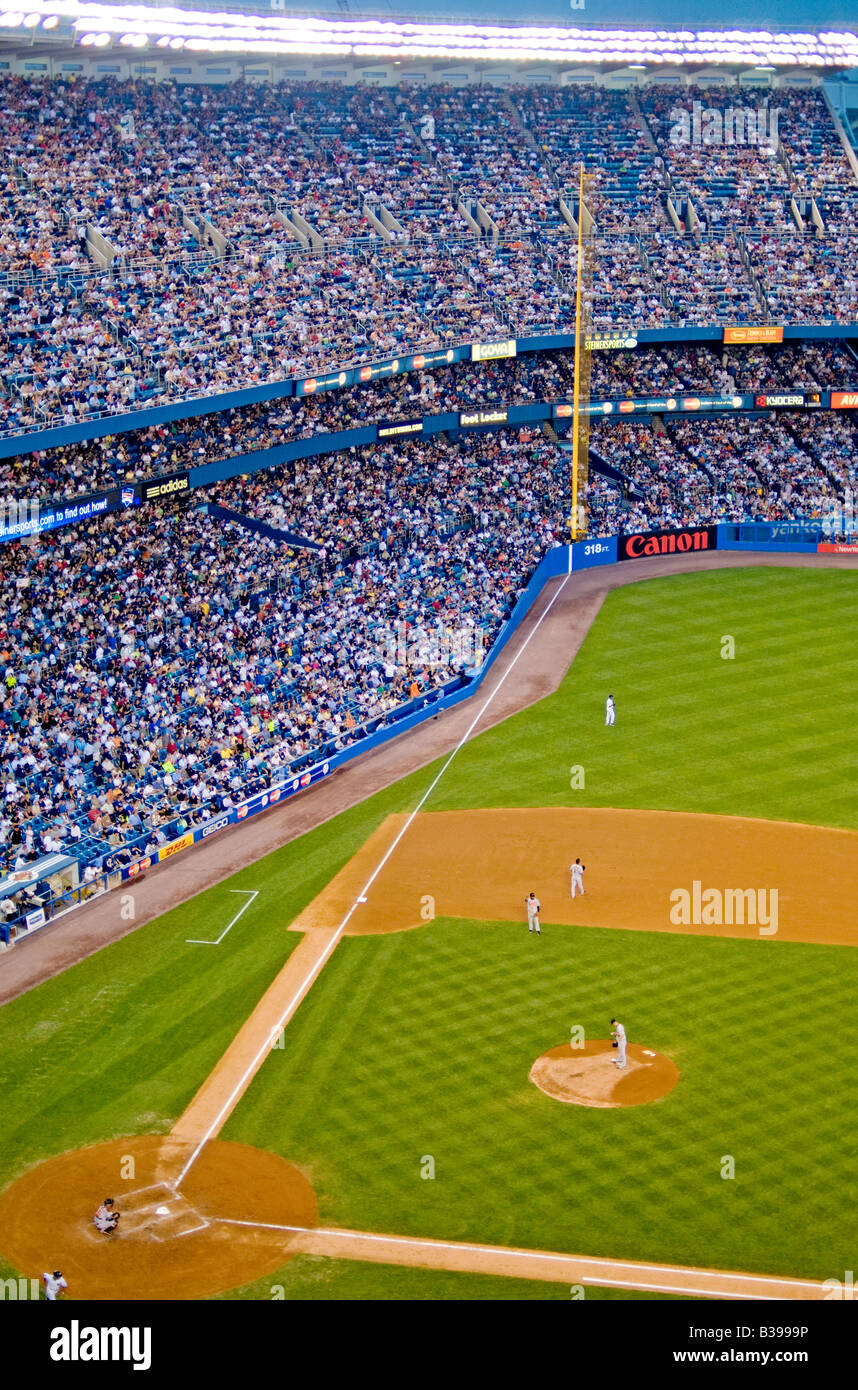 Yankee Stadium Baseball Game New York City // THE BRONX, New York City, Stati Uniti — Una partita di baseball è in corso presso il vecchio Yankee Stadium, con i New York Yankees che affrontano i Baltimore Orioles. Il luogo iconico, noto come "la casa che Ruth ha costruito", ospita una folla di appassionati appassionati che guardano il passatempo americano. Lo storico stadio, con la sua caratteristica facciata e il Monument Park, fa da sfondo alle tradizioni del baseball, mentre due rivali dell'American League East competono sul diamante. Foto Stock