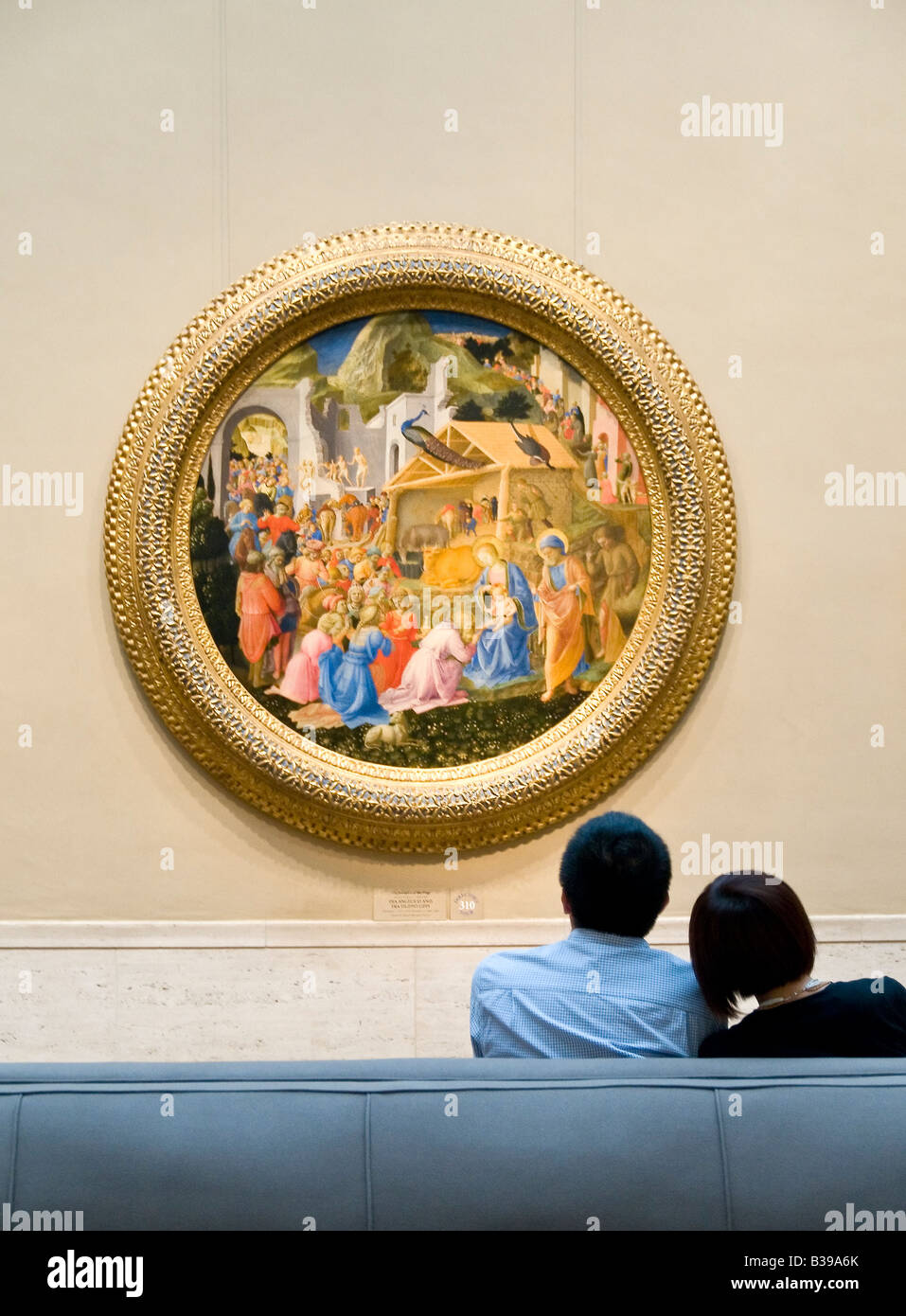 Adoration of the Magi National Gallery of Art Washington DC // WASHINGTON DC — Una coppia siede su una panchina ammirando il dipinto "Adoration of the Magi" di fra Angelico e Filippo Lippi, 1440-1460, in mostra alla National Gallery of Art di Washington DC. L'opera rinascimentale raffigura la scena biblica dei tre Re che presenta doni al bambino Gesù. Foto Stock