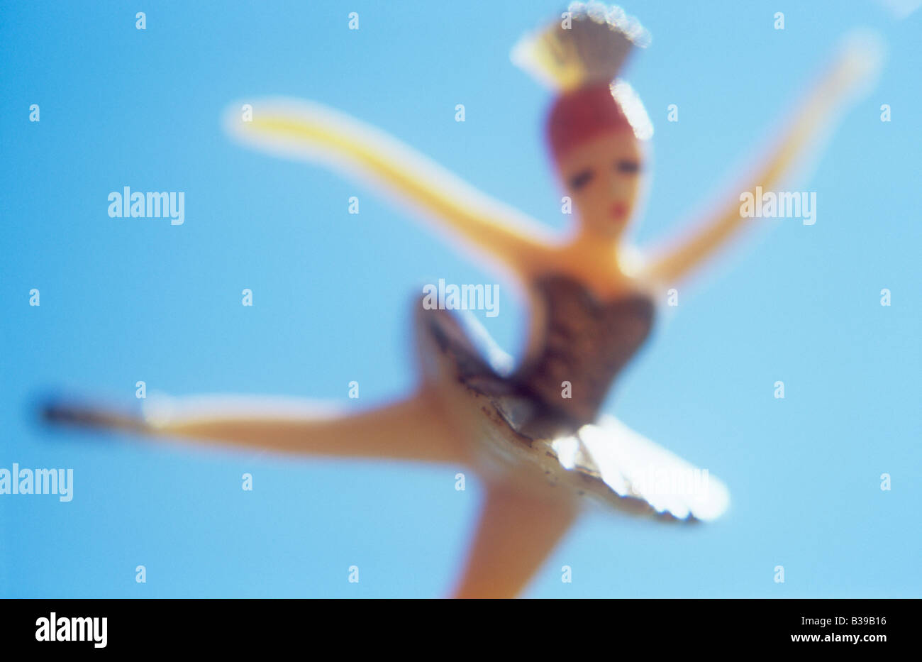 Impressionistica close up del modello della ballerina bilanciato su una gamba o jumping rivolta verso il viewer con cielo blu dietro Foto Stock