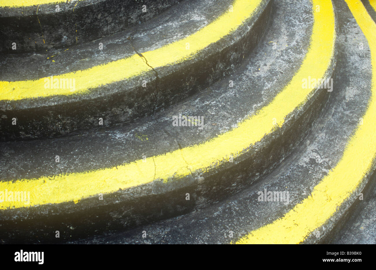 Dettaglio del semi-volo circolare di passi concreti colorate con agenti atmosferici ma con ampia giallo ad alta visibilità la vernice sui bordi Foto Stock