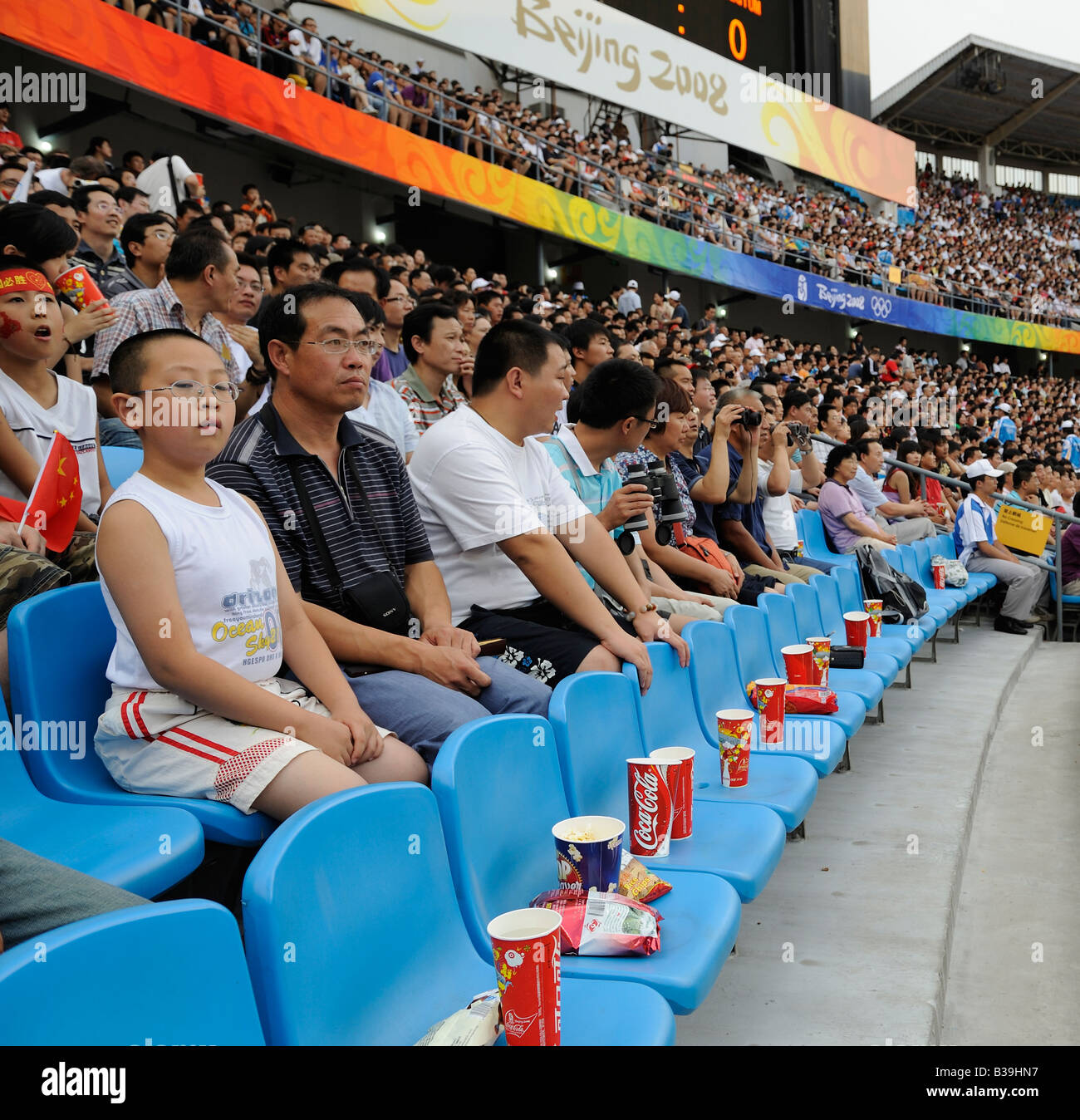 Gli spettatori cinesi guardare una partita di football guarda con la coca-cola ai Giochi Olimpici di Pechino 2008.16-Aug-2008 Foto Stock