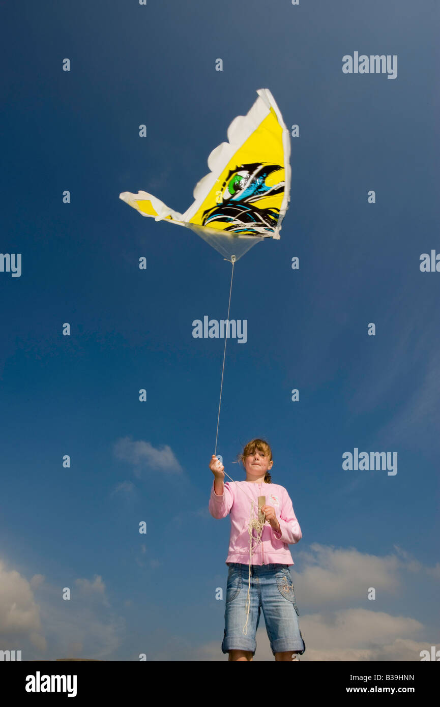 Giovane ragazza che gioca con il kite colorati contro il cielo blu Cumbria Inghilterra England Foto Stock