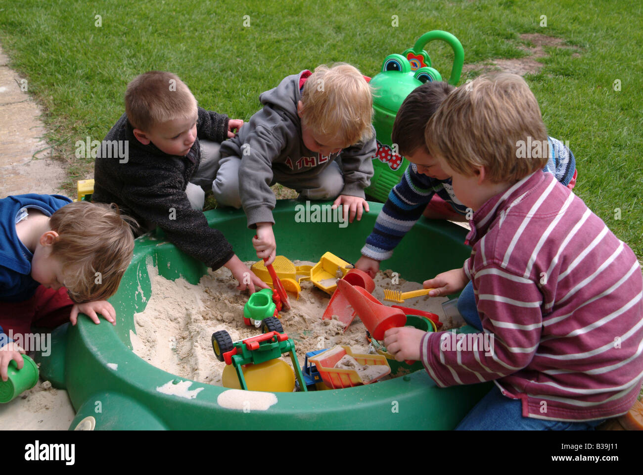 Un gruppo di bambini che giocano in una buca di sabbia Foto Stock