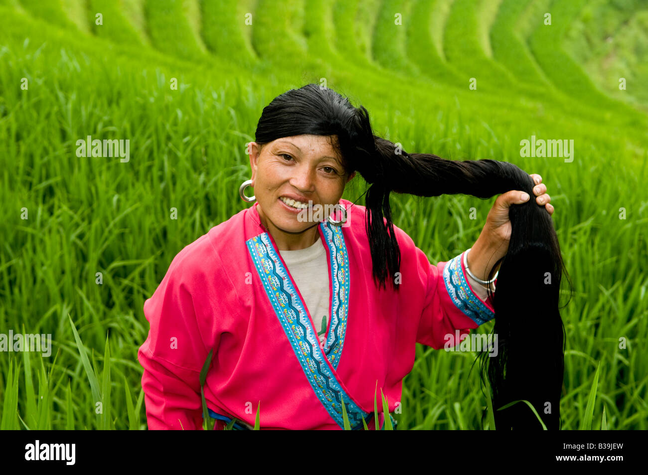 Un bel rosso Yao mostra off i suoi lunghi capelli in Longji terrazze di riso, Guangxi, Cina Foto Stock