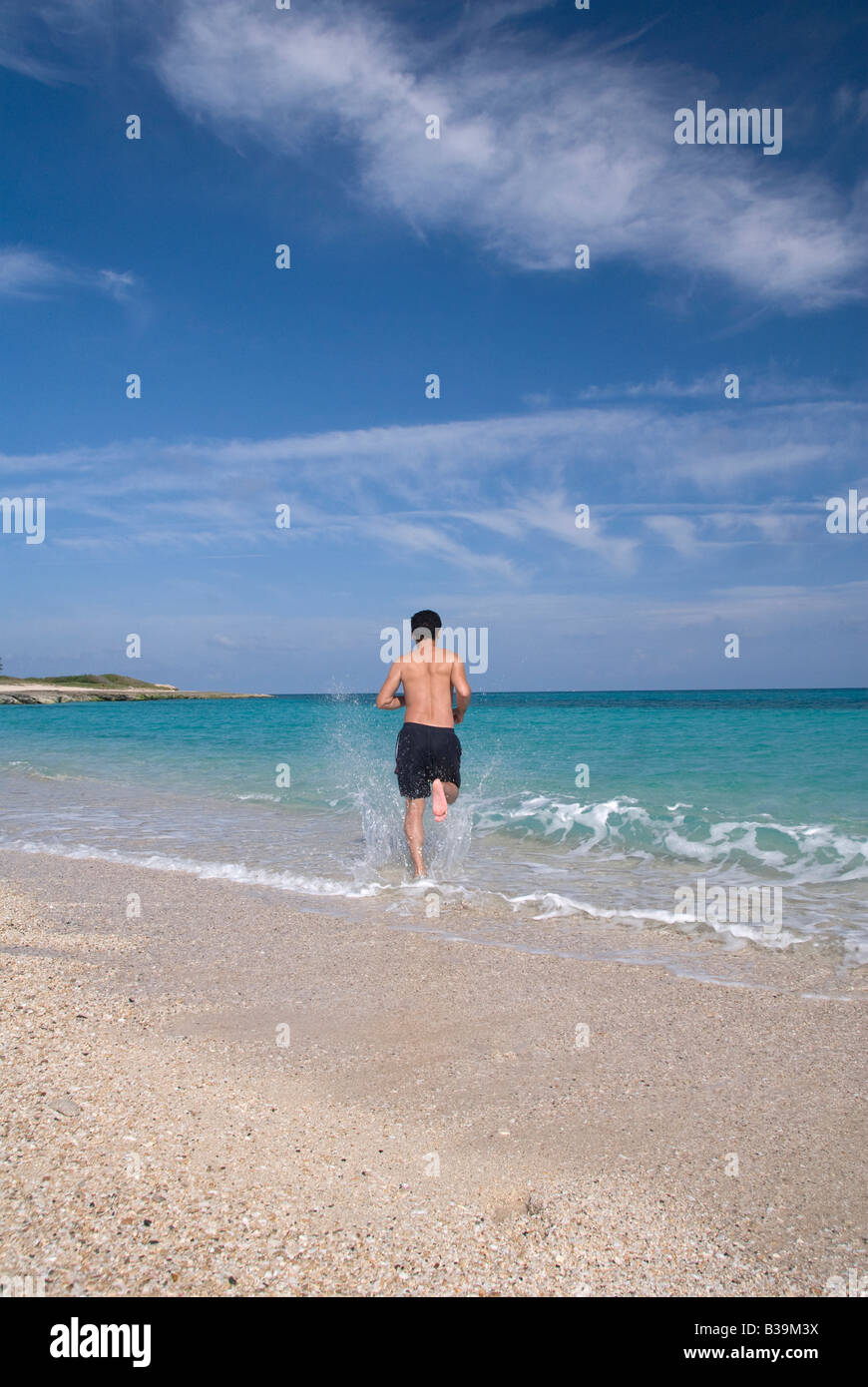 Una vacanza estiva di un uomo che corre in mare Foto Stock
