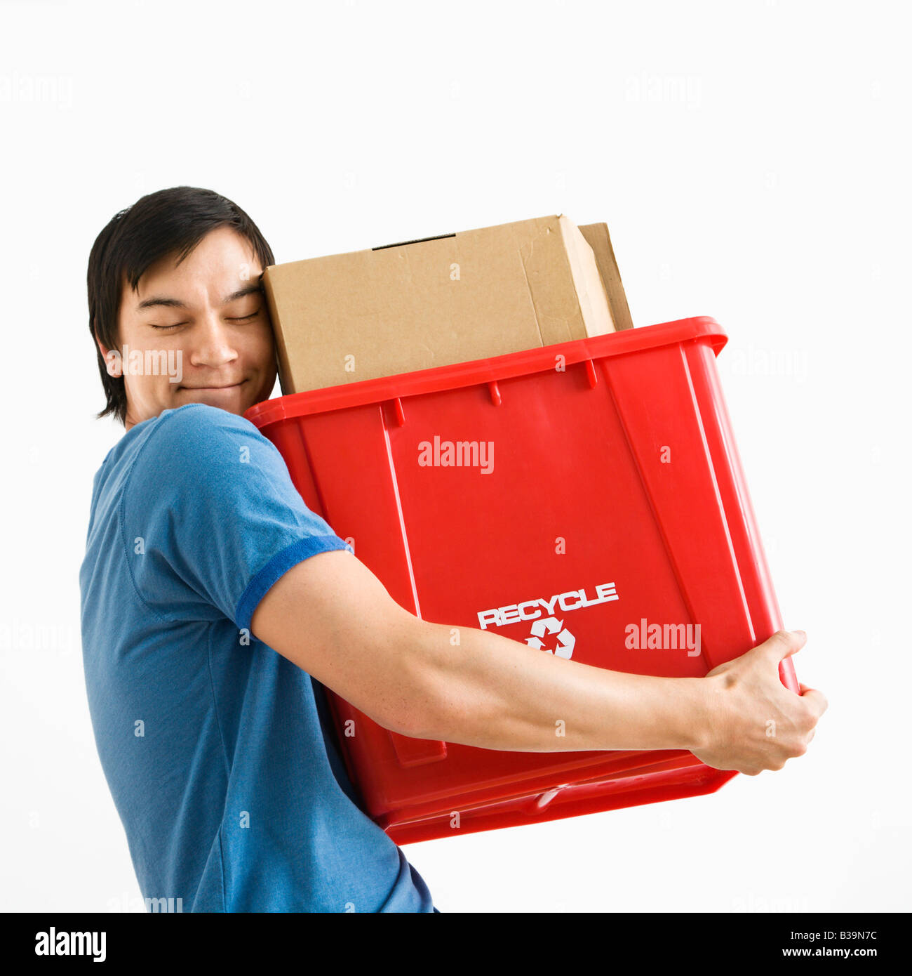 Ritratto di sorridere Asian giovane tenendo il contenitore di riciclaggio Foto Stock