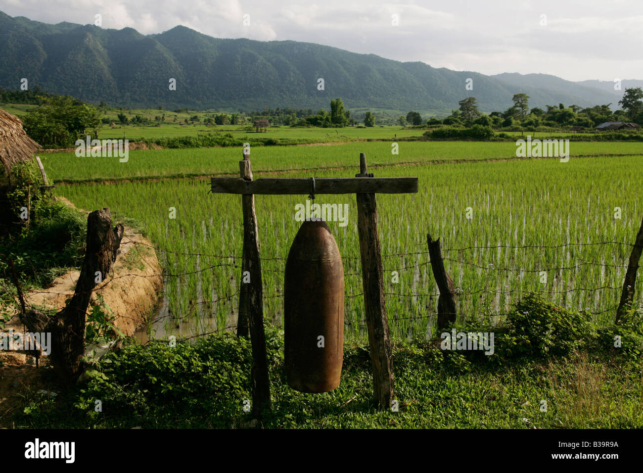 Nong Het district, Xieng Khouang provincia, Laos. Il 2000 lb bomb involucro utilizzato come un villaggio campana è infilate tra posti di legno Foto Stock