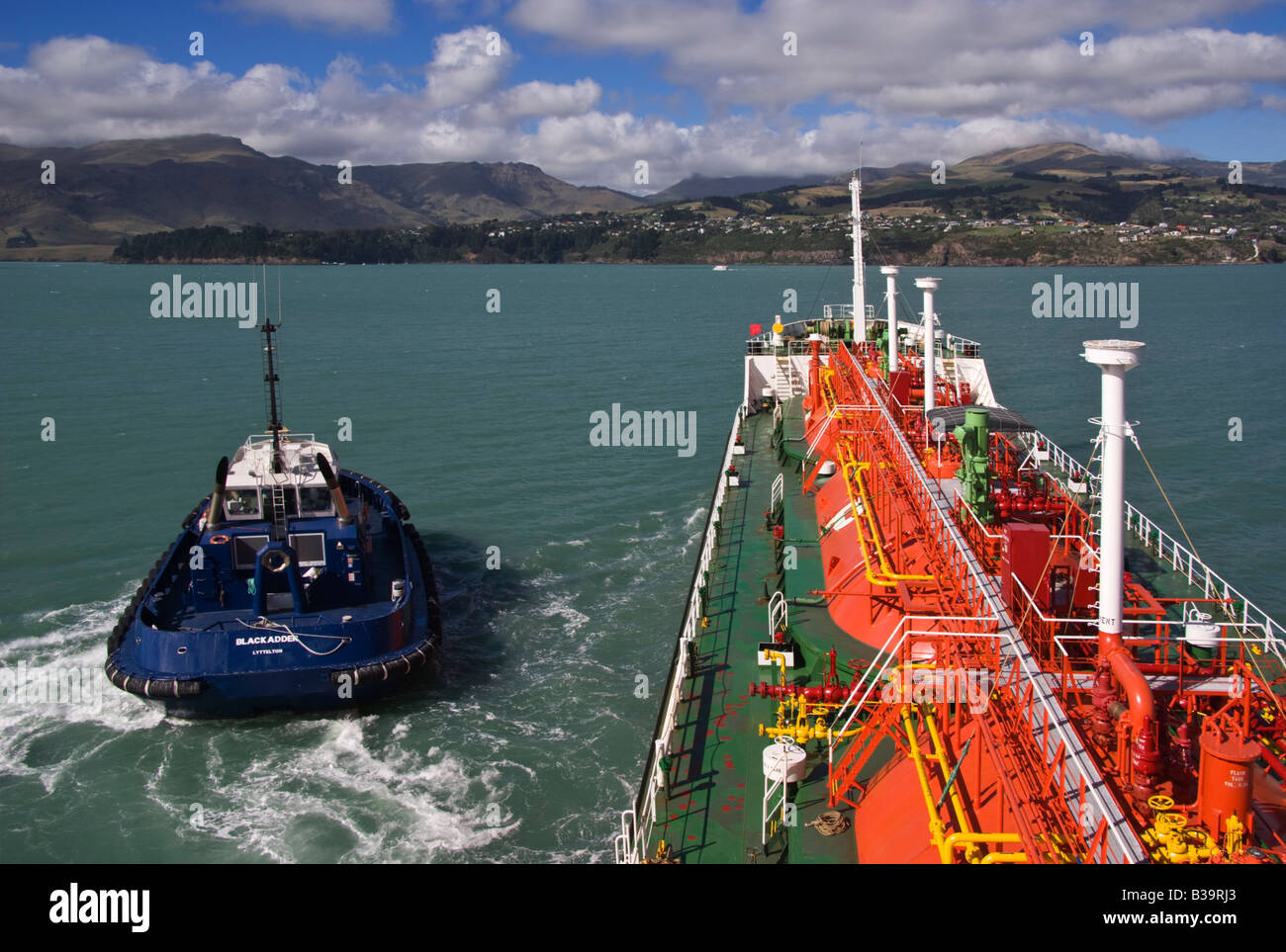 Un rimorchiatore lascia una tanica di benzina avere assistito di discostarsi è posto di ormeggio nel porto di Lyttelton, Nuova Zelanda. Foto Stock