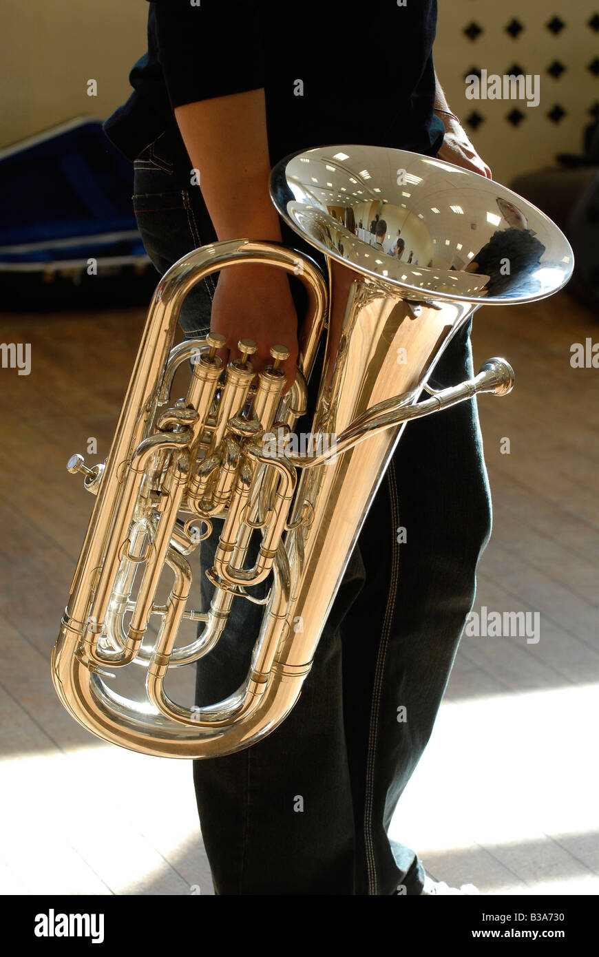 Musicista attraversando Soleggiato monolocale piano portante una tuba Foto Stock