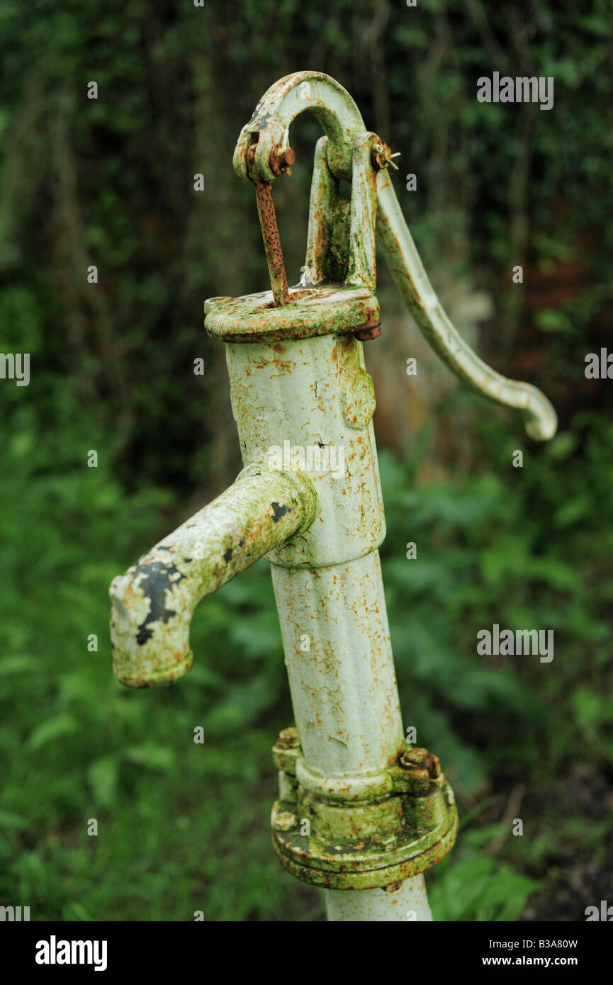 Una vecchia pompa acqua, poco arrugginimento raffigurato in un giardino nel Devon, Regno Unito Foto Stock