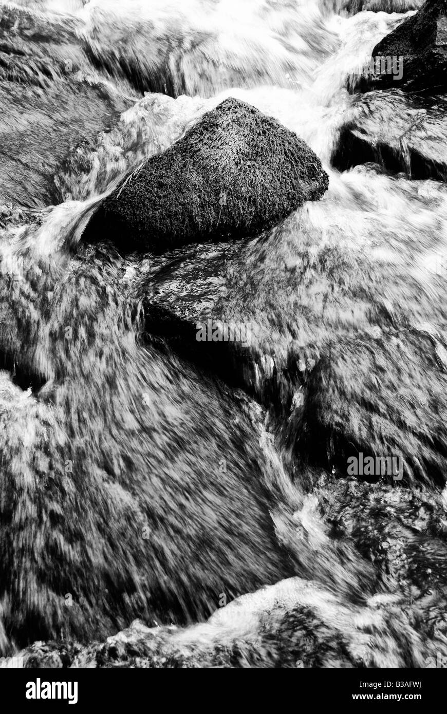 In prossimità di acqua sfocata impetuoso tra rocce al latticello cade Foto Stock