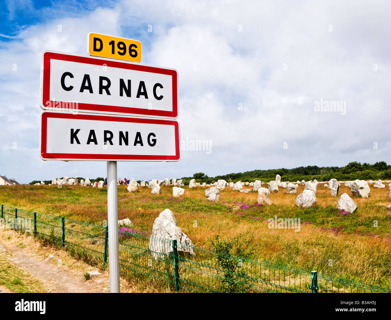 Carnac, Brittany, Francia - Alignements du Menec pietre permanente con il cartello stradale in francese e il bretone lingue Foto Stock