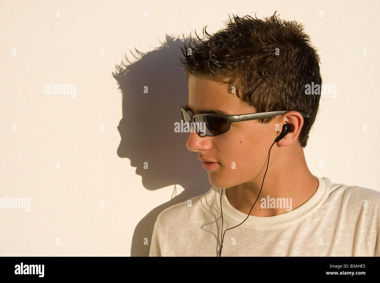 Ragazzo adolescente con occhiali da sole e i-pod Foto Stock