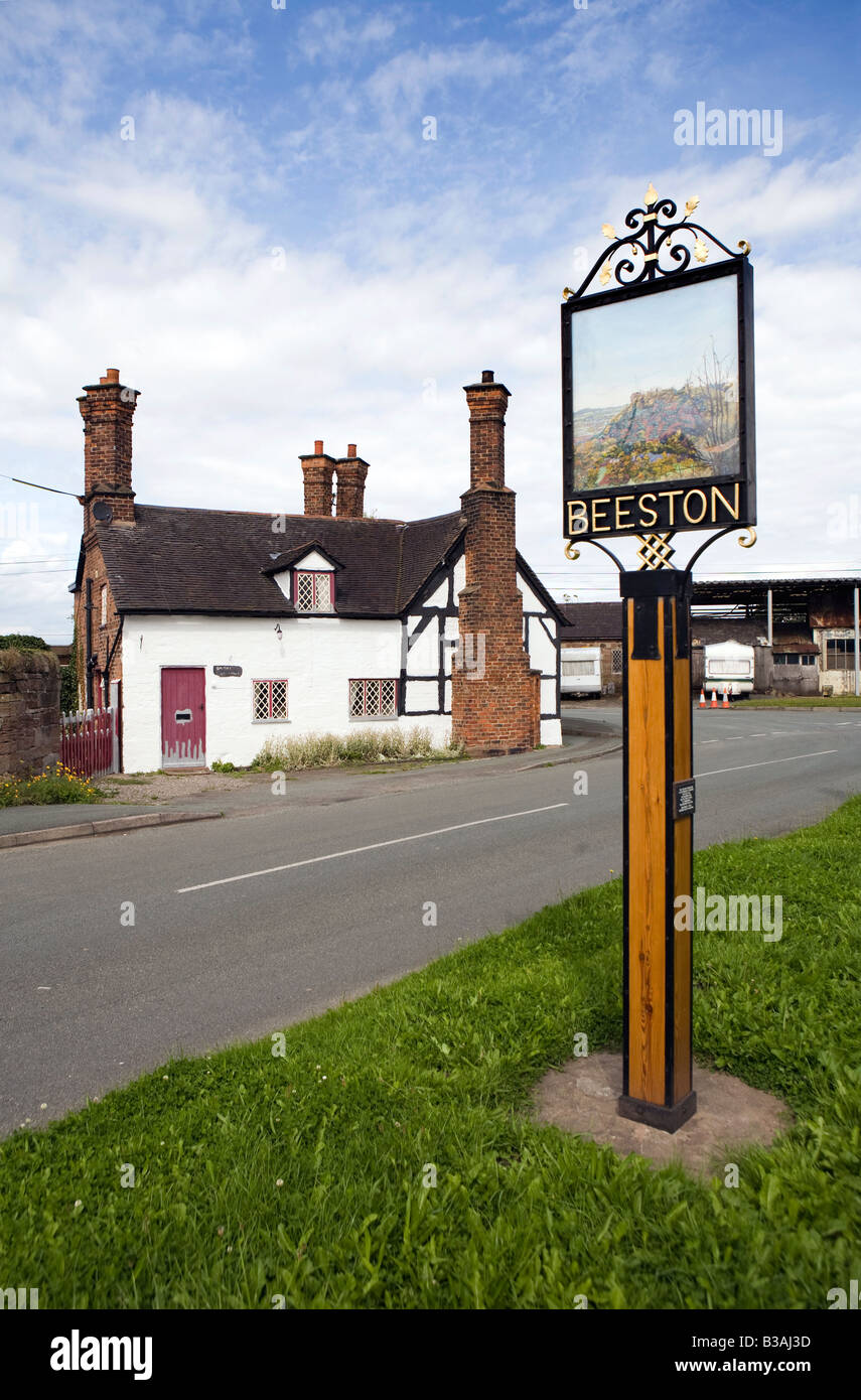 Regno Unito Cheshire Beeston caratteristico castello di Peckforton station wagon cottage e segno di villaggio Foto Stock