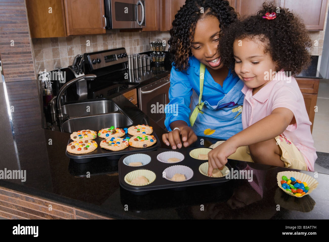 Madre africana e figlia rendendo i tortini Foto Stock