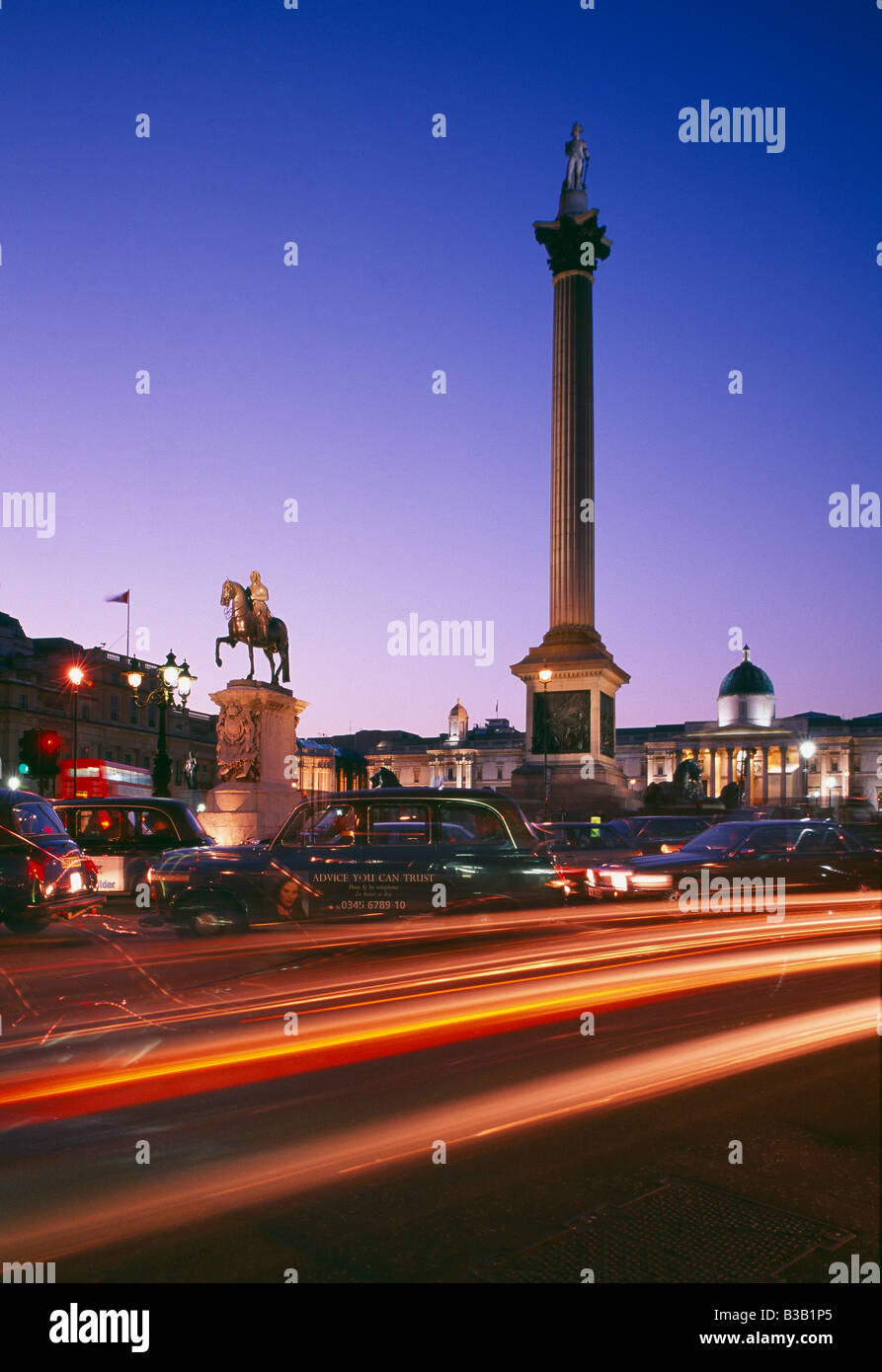 Nelson la colonna e i taxi di Londra (black cabs) in Trafalgar Square al crepuscolo, London, England, Regno Unito Foto Stock
