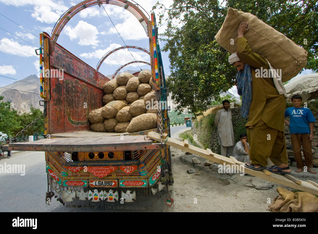 Uomo pakistano Patate di carico su un camion nella valle di Hunza nel nord del Pakistan Foto Stock