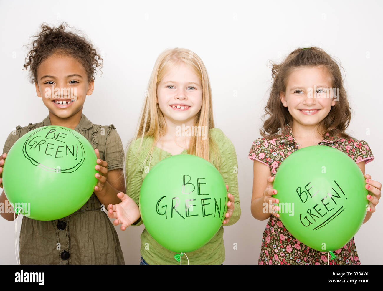 Multi-etnico ragazze azienda palloncini verde Foto Stock