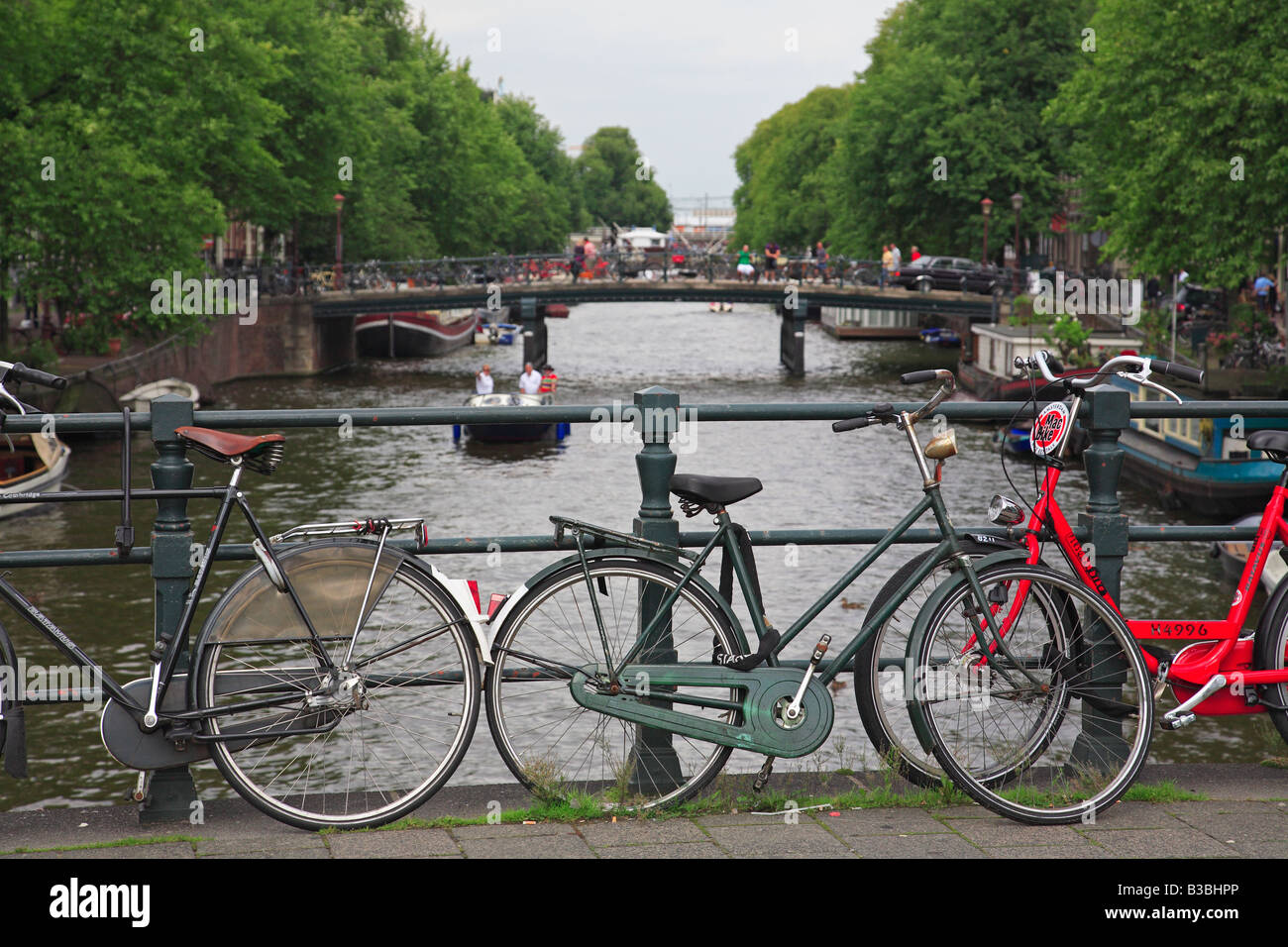 Biciclette olandesi schierate contro un ponte sul canale di Amsterdam Foto Stock