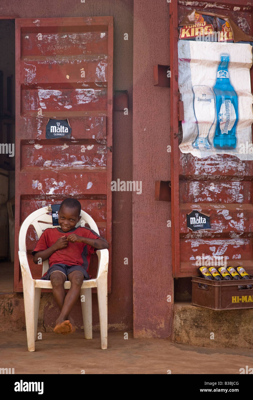 Un ragazzo salotti davanti a un bar di Enugu, in Nigeria. Foto Stock