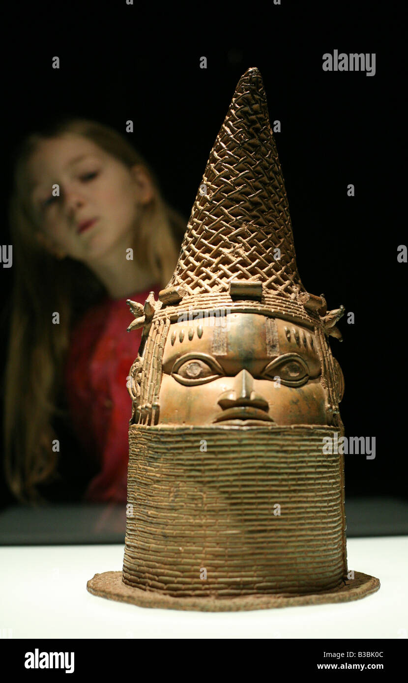 Giovane visitatore guardando la regina di testa in bronzo del Benin nella collezione del museo etnologico di Berlino Dahlem, Germania Foto Stock