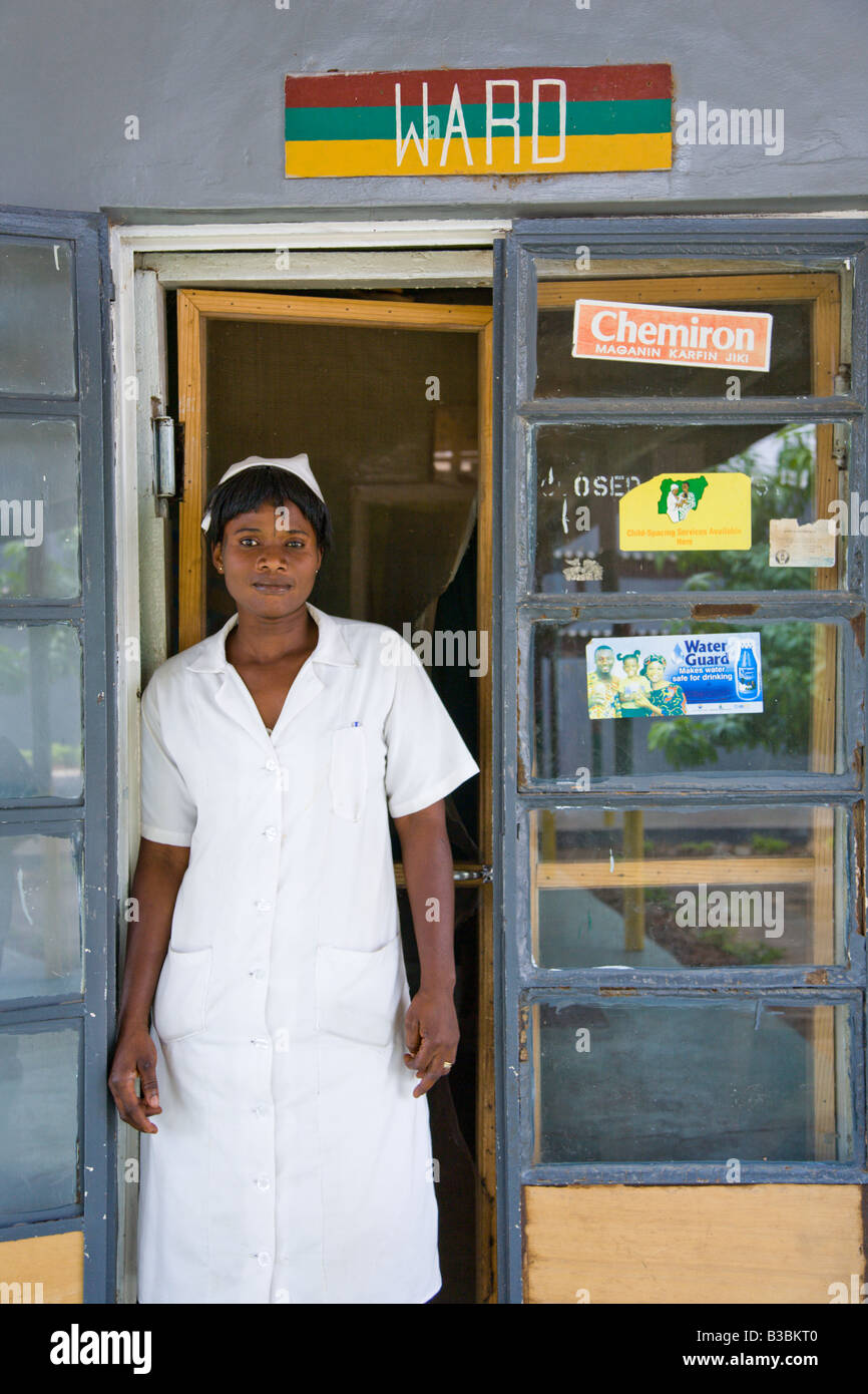 Un ufficiale sanitario presso la caserma di Bukavu clinica pubblica di Kano Nigeria sorge accanto a un messaggio pubblicitario Waterguard. Foto Stock