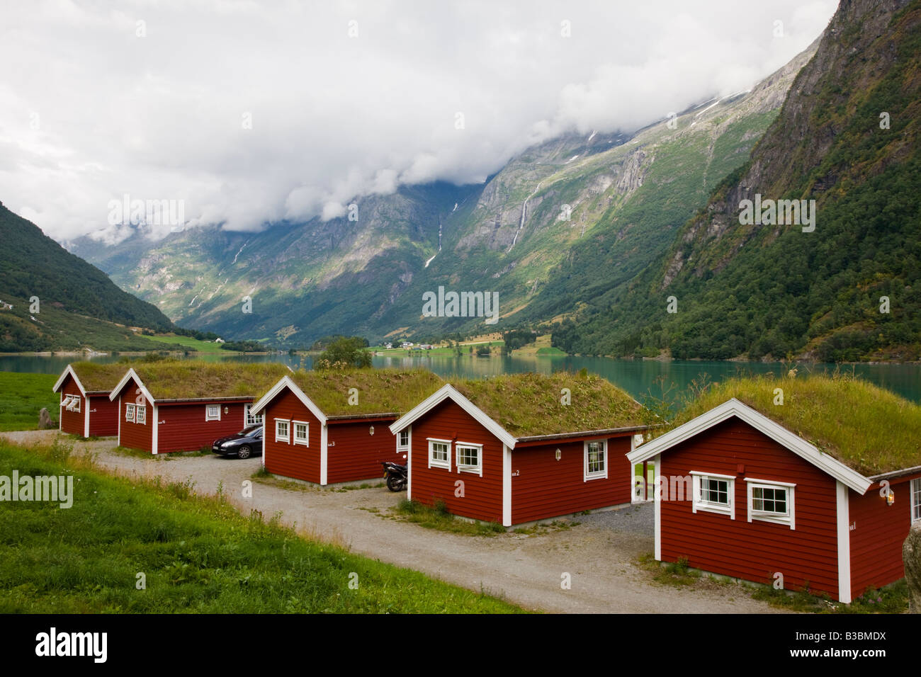 Campeggio cottage con tetti di erba Fjaerland Norvegia Scandinavia accanto al lago glaciale Loen Norvegia in vista delle cascate Foto Stock