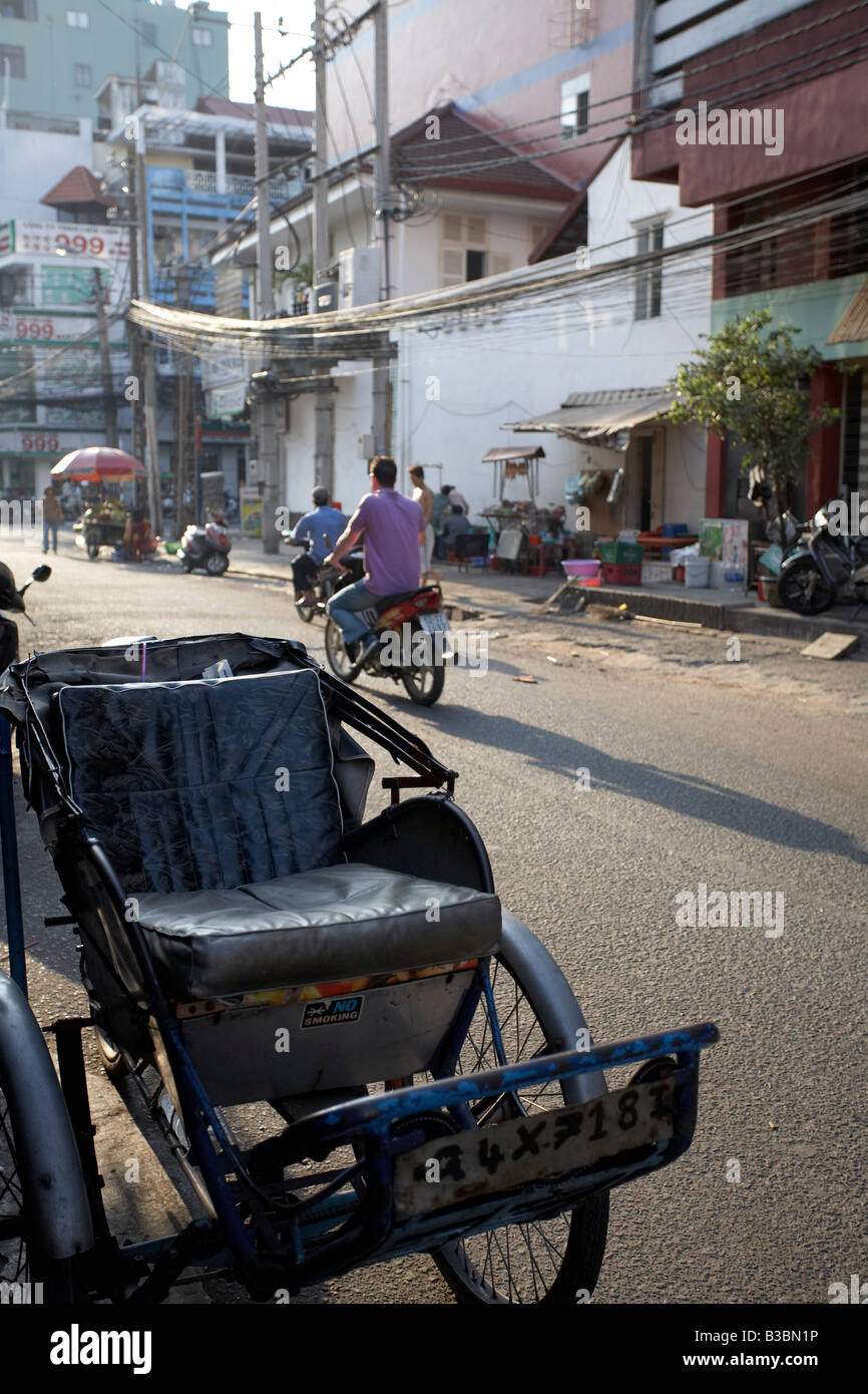 In rickshaw sul lato della strada e la città di Ho Chi Minh, Vietnam Foto Stock