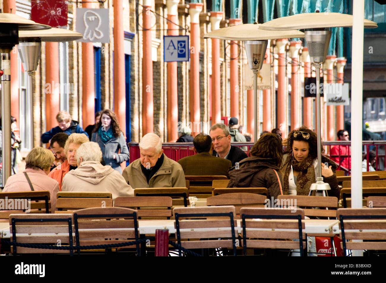 I cittadini anziani e giovani ragazze in un cafe, Convent Garden di Londra, Inghilterra Foto Stock