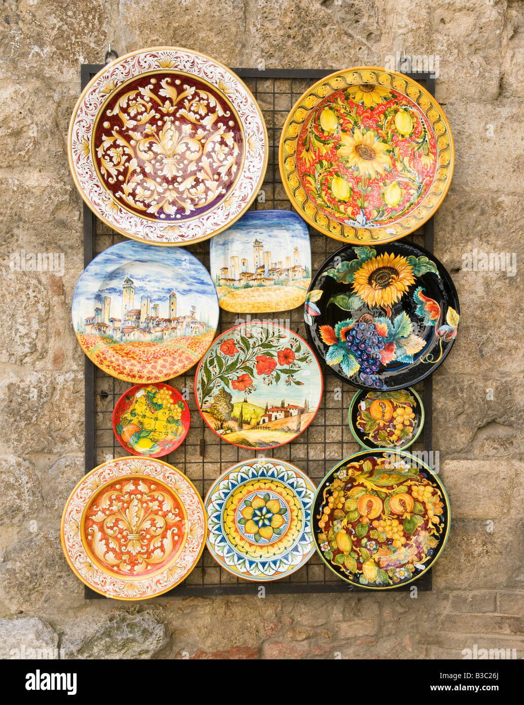 Le piastre colorate al di fuori del negozio di ceramiche in San Gimignano, Valle de Orcia, Toscana, Italia Foto Stock