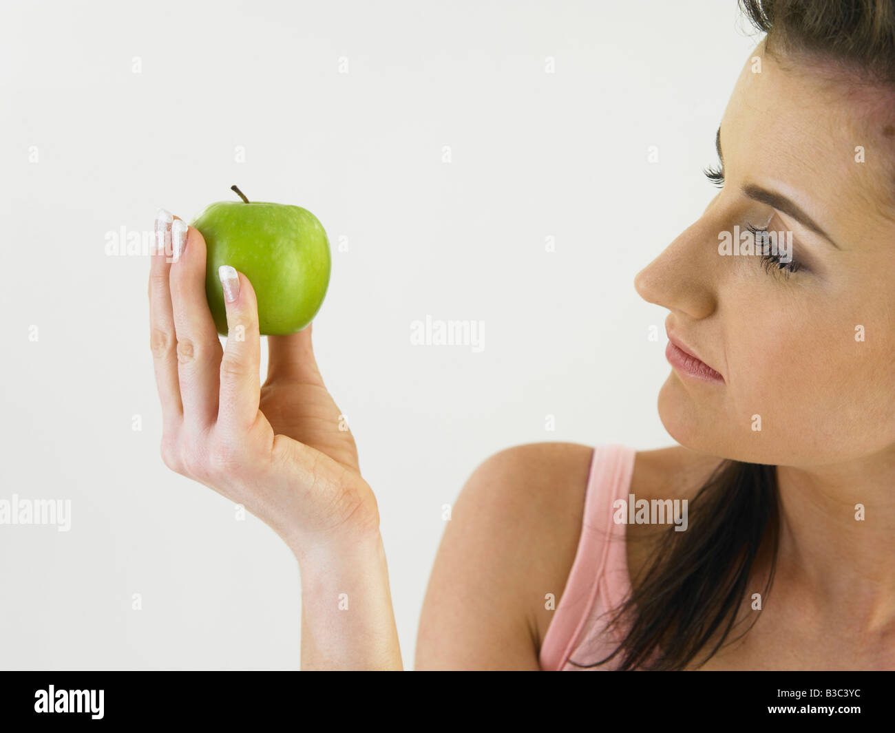 Donna che guarda all'apple Foto Stock