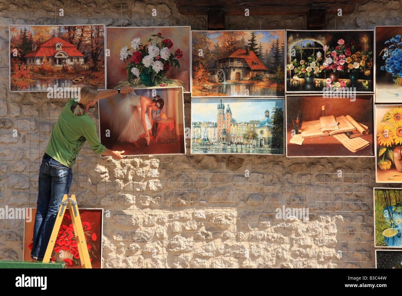 Un venditore di arte visualizza la sua mercanzia in vendita sulla parete del Barbican, Cracovia in Polonia Foto Stock