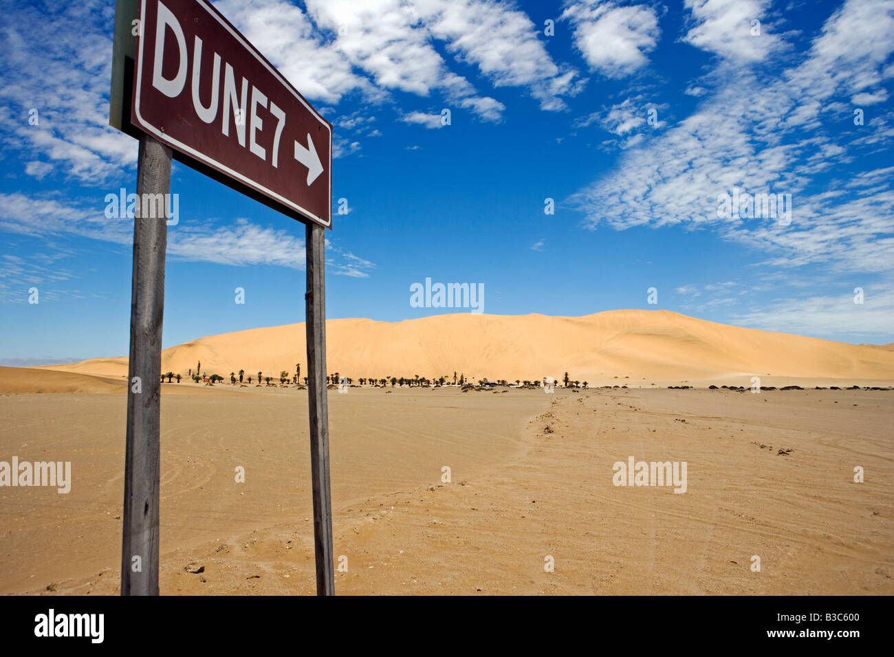 La Namibia, Skeleton Coast, a Walvis Bay. Il segno per la famosa zona turistica di duna duna 7 situato vicino a Walvis Bay e Swakopmund. Dune 7 è una grande duna di sabbia nel deserto del Namib, uno dei più grandi del mondo e la più alta della fascia costiera popolare con sandboarders. Foto Stock