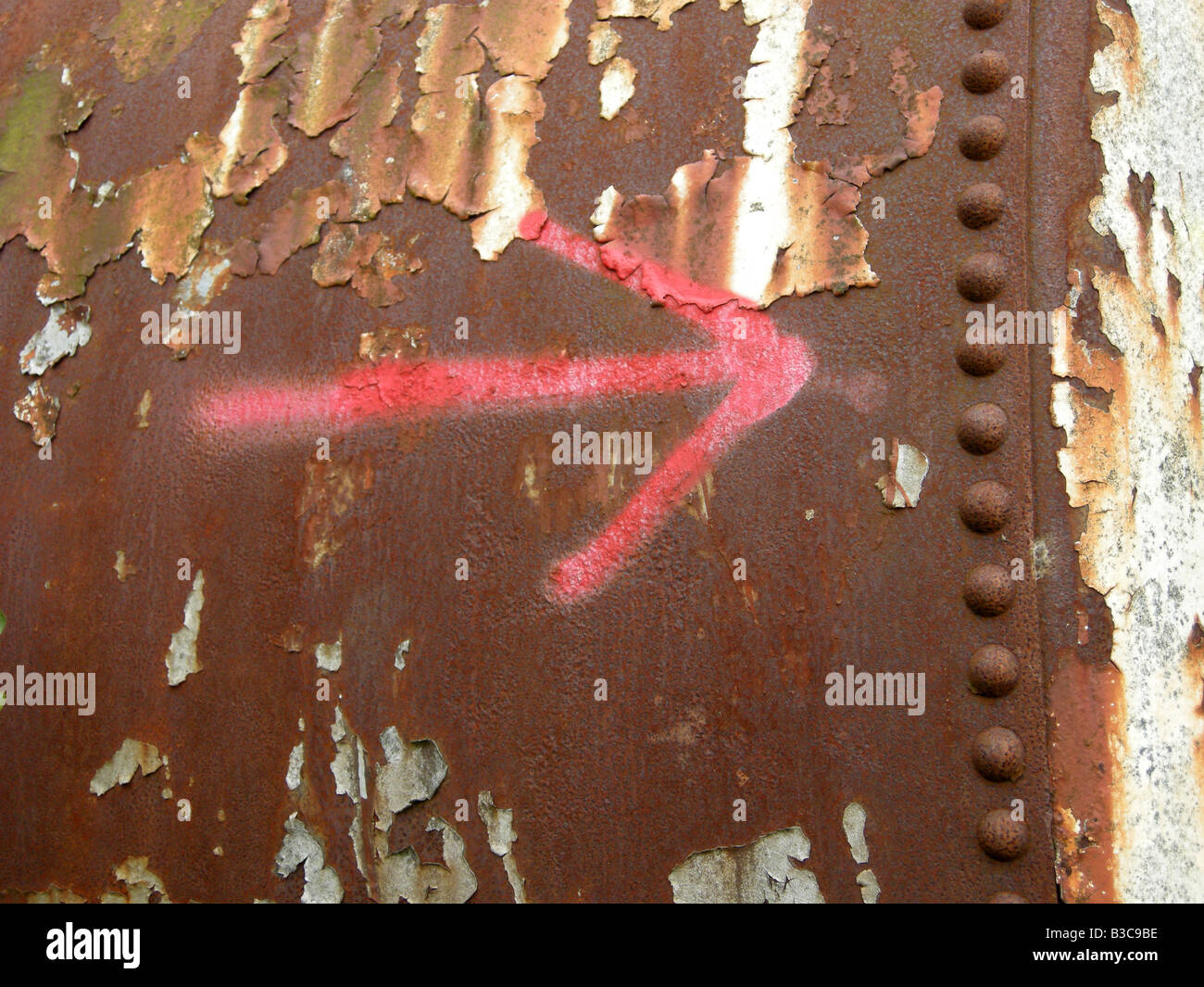 Dipinto di rosso freccia su un metallo arrugginito sfondo Foto Stock